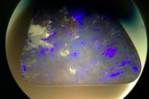farbiger Einschluss mit Diffraktionsinterferenz in einem Boulder-Opal