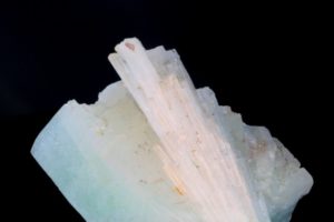Scolezitkristalle auf einem grünen Apophyllitkristall aus Brasilien